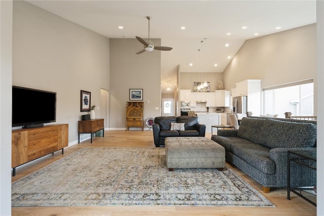 living room featuring high vaulted ceiling, ceiling fan, and light hardwood / wood-style floors