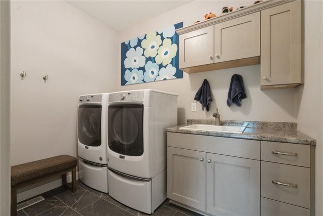 laundry room featuring independent washer and dryer, cabinets, and sink