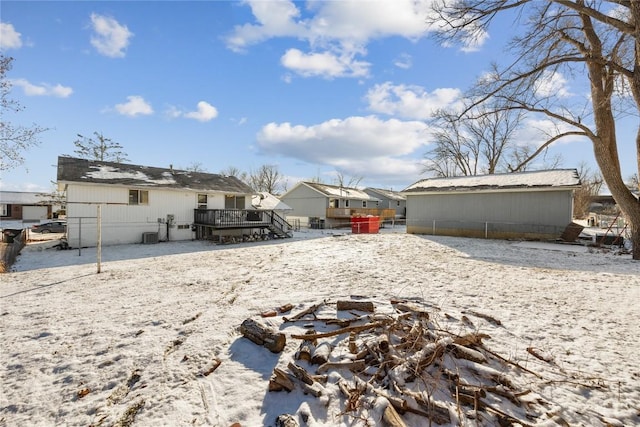 snowy yard featuring a deck and cooling unit