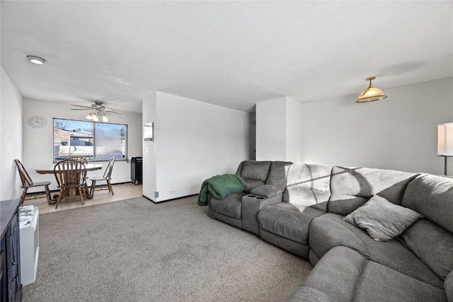 carpeted living room featuring ceiling fan