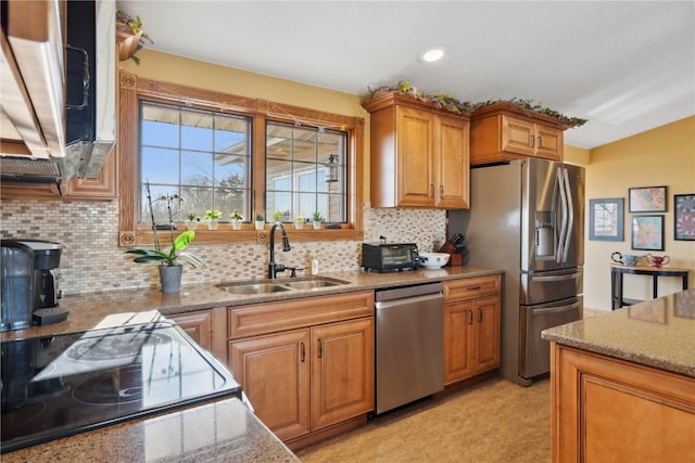 kitchen with sink, stainless steel appliances, decorative backsplash, and light stone countertops