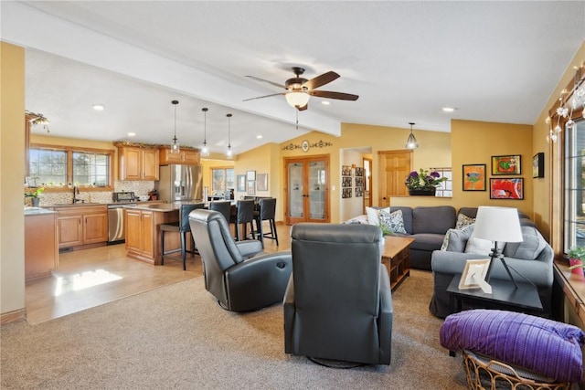 living room with ceiling fan, lofted ceiling with beams, and light carpet