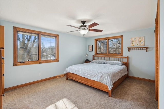 carpeted bedroom with multiple windows and ceiling fan