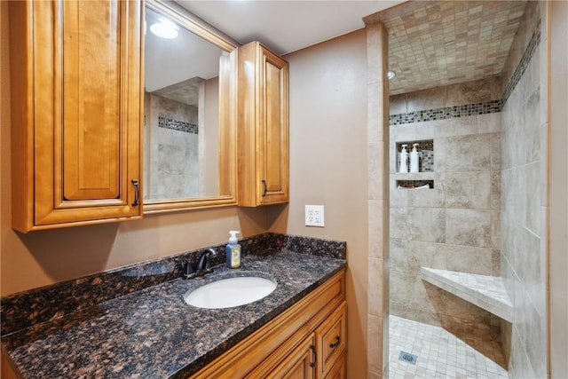 bathroom featuring tiled shower and vanity