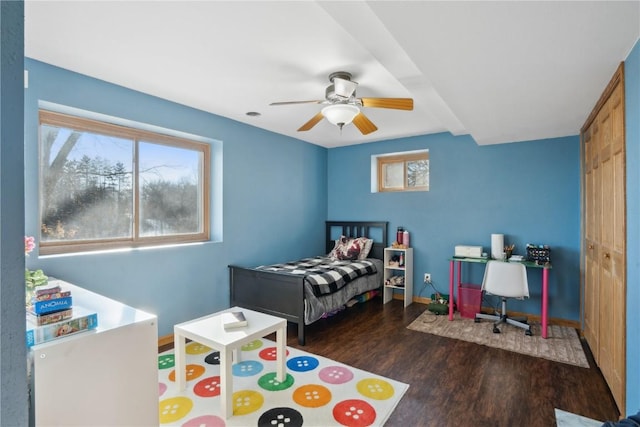 bedroom featuring multiple windows, a closet, ceiling fan, and dark wood-type flooring