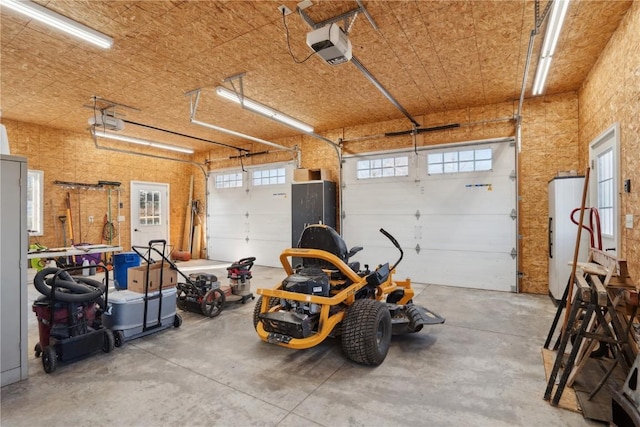 garage with a garage door opener and white refrigerator