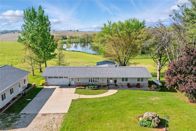 1394 210th St, Tipton, IA 52772 - view of front facade with a water view, concrete driveway, a garage, and a front yard