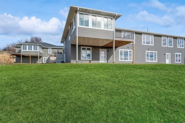 rear view of property featuring a lawn