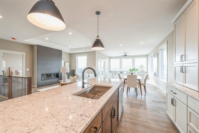 618 J Ave NE, Cedar Rapids, IA 52402 - kitchen featuring a sink, light wood-style flooring, recessed lighting, hanging light fixtures, and light stone countertops