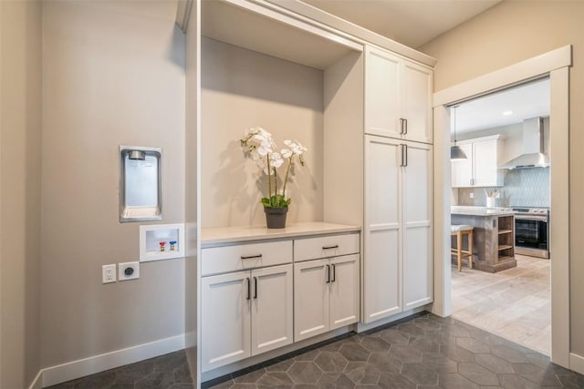 interior space with hookup for a washing machine, electric dryer hookup, and cabinets