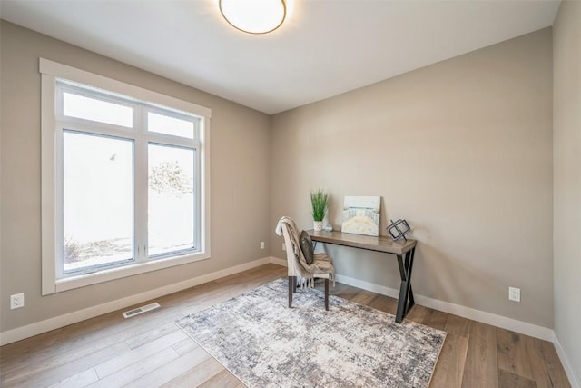 office space with plenty of natural light and light hardwood / wood-style flooring