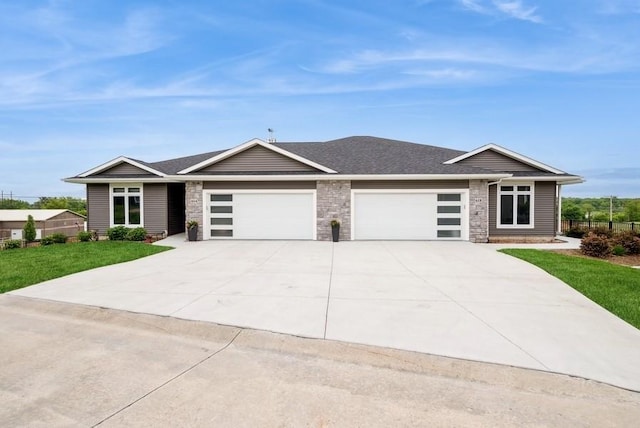 618 J Ave NE, Cedar Rapids, IA 52402 - view of front of house featuring an attached garage, concrete driveway, stone siding, and a shingled roof