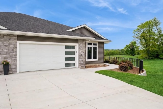 618 J Ave NE, Cedar Rapids, IA 52402 - view of front facade with stone siding, concrete driveway, roof with shingles, and an attached garage