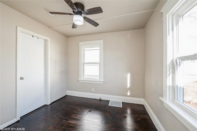 interior space with ceiling fan, plenty of natural light, and dark hardwood / wood-style floors