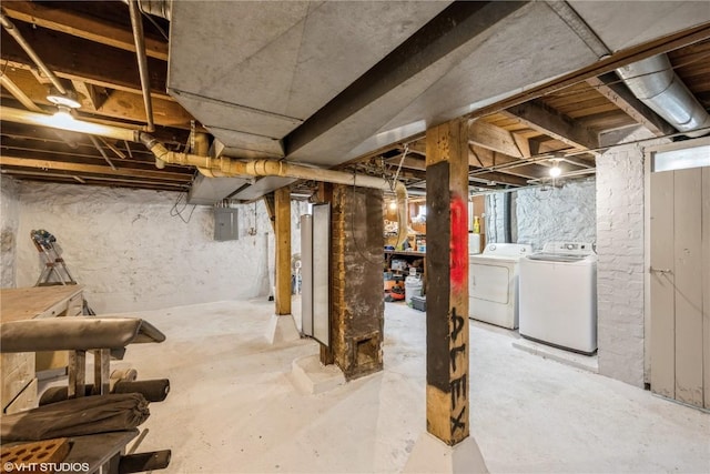 basement featuring electric panel and washing machine and clothes dryer