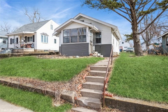 bungalow-style home with covered porch and a front yard