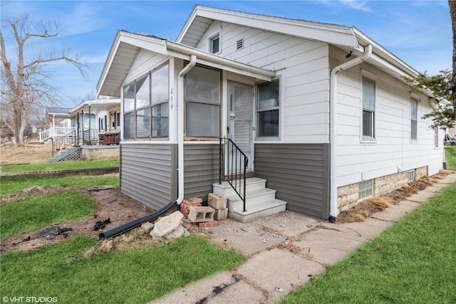 view of front of property featuring a front yard and a sunroom