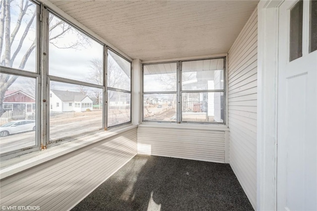 unfurnished sunroom featuring wooden ceiling and a wealth of natural light