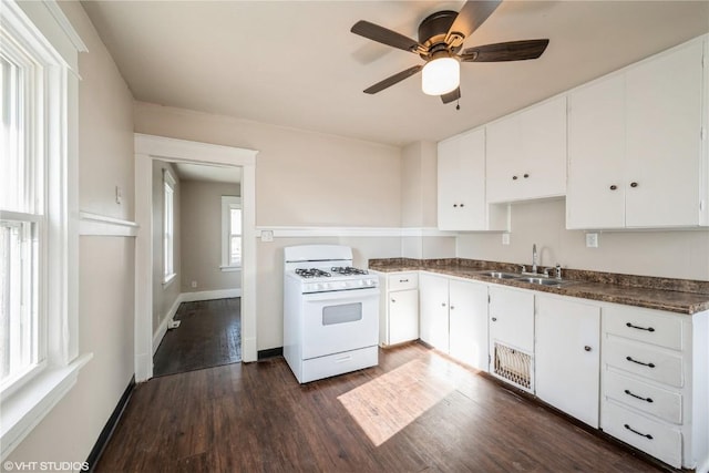 kitchen featuring white cabinets, dark hardwood / wood-style floors, sink, and white gas range