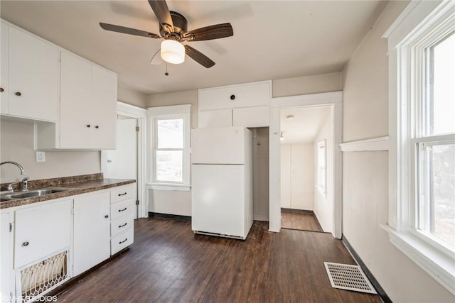 kitchen with white cabinetry, dark hardwood / wood-style flooring, white fridge, sink, and plenty of natural light