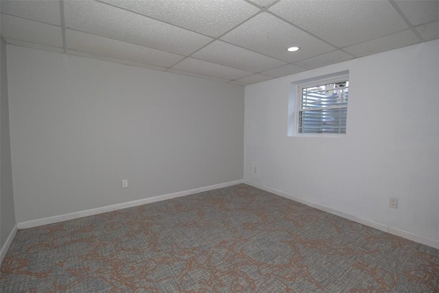 spare room featuring carpet and a paneled ceiling