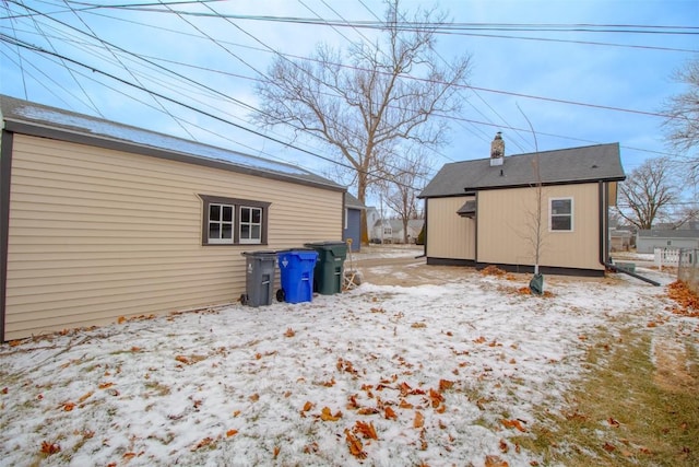 view of snow covered back of property