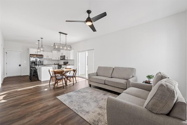 living room featuring ceiling fan and dark hardwood / wood-style flooring