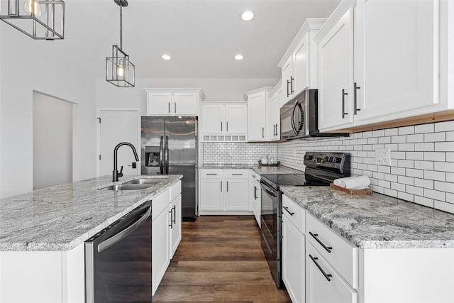 kitchen featuring black appliances, hanging light fixtures, and white cabinetry