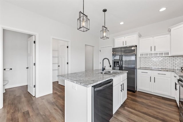 kitchen with appliances with stainless steel finishes, white cabinetry, sink, hanging light fixtures, and a kitchen island with sink