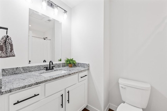 bathroom with toilet, vanity, and a shower with shower curtain