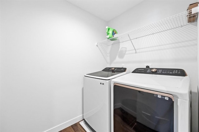 clothes washing area featuring dark wood-type flooring and separate washer and dryer