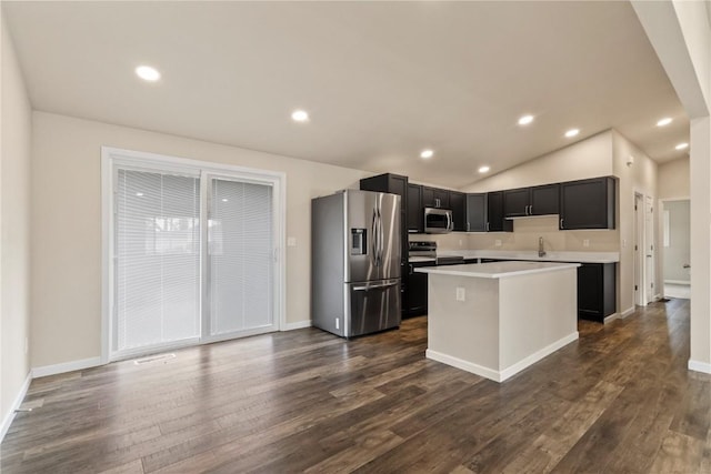 kitchen featuring sink, stainless steel appliances, a center island, dark hardwood / wood-style flooring, and vaulted ceiling