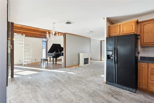 kitchen with black refrigerator with ice dispenser, hanging light fixtures, and a notable chandelier