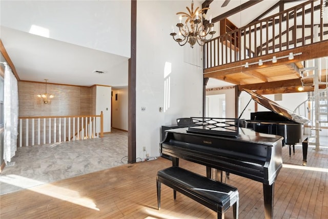 miscellaneous room featuring light wood-type flooring, a healthy amount of sunlight, and a notable chandelier