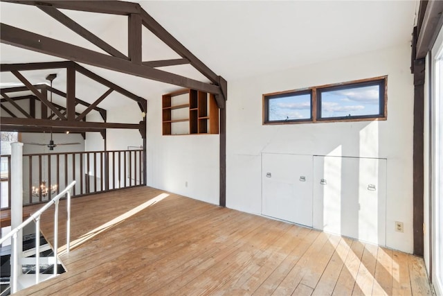 foyer entrance featuring hardwood / wood-style flooring, ceiling fan, and vaulted ceiling with beams