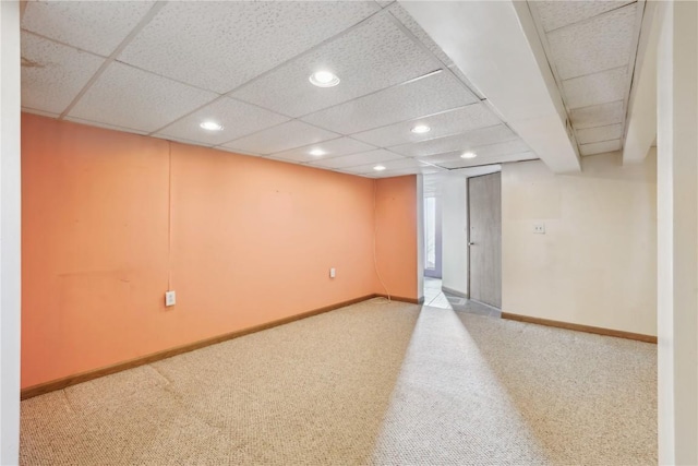 basement featuring carpet and a paneled ceiling