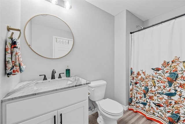 bathroom with wood-type flooring, toilet, and vanity