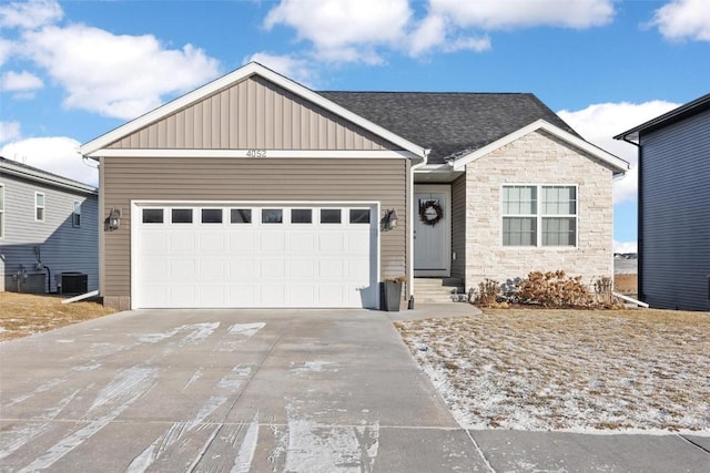 view of front of home featuring central air condition unit and a garage