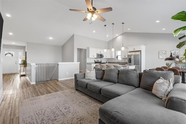 living room with high vaulted ceiling, ceiling fan, and hardwood / wood-style floors