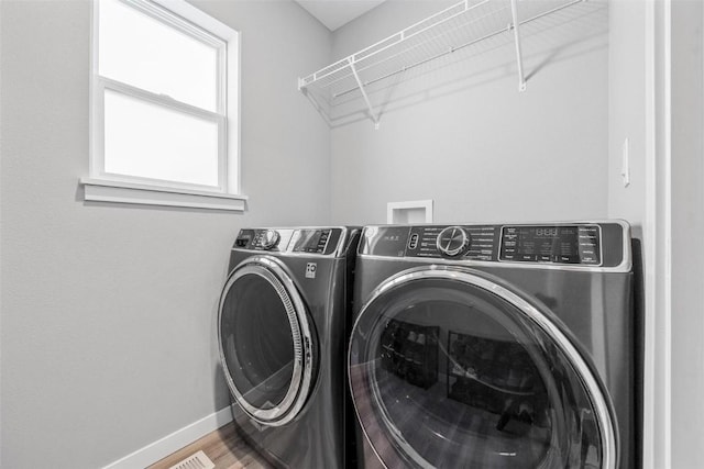 washroom with hardwood / wood-style flooring and independent washer and dryer