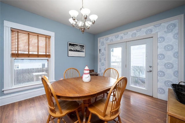 dining area featuring dark wood-type flooring, french doors, and a notable chandelier