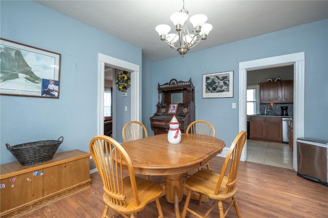 dining area featuring light hardwood / wood-style floors and a notable chandelier