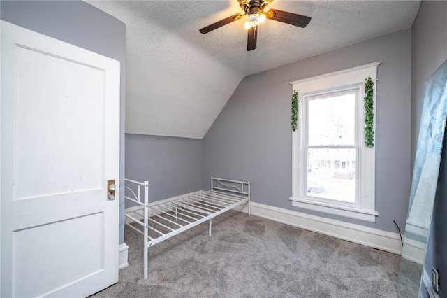 additional living space featuring a textured ceiling, ceiling fan, vaulted ceiling, and light colored carpet