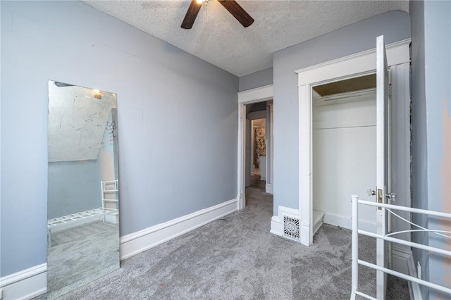 unfurnished bedroom featuring ceiling fan, a closet, a textured ceiling, and carpet flooring