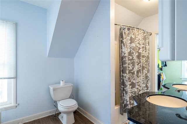 full bathroom featuring lofted ceiling, vanity, toilet, hardwood / wood-style floors, and shower / tub combo with curtain