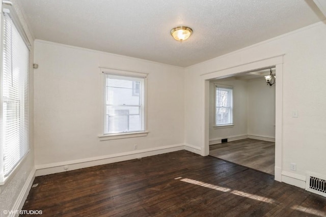 unfurnished room featuring dark hardwood / wood-style flooring, a textured ceiling, and ornamental molding