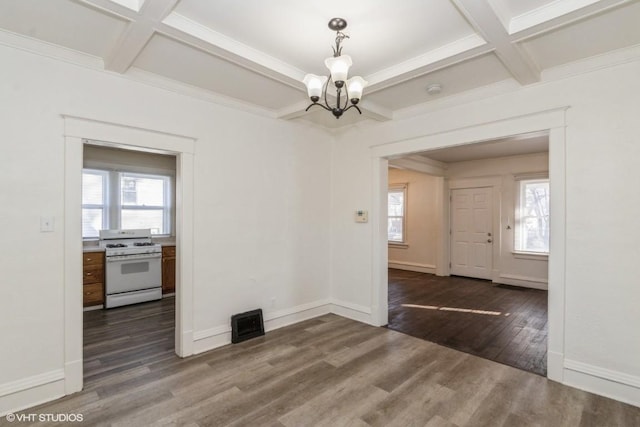 unfurnished dining area with dark wood-type flooring, an inviting chandelier, ornamental molding, beam ceiling, and coffered ceiling