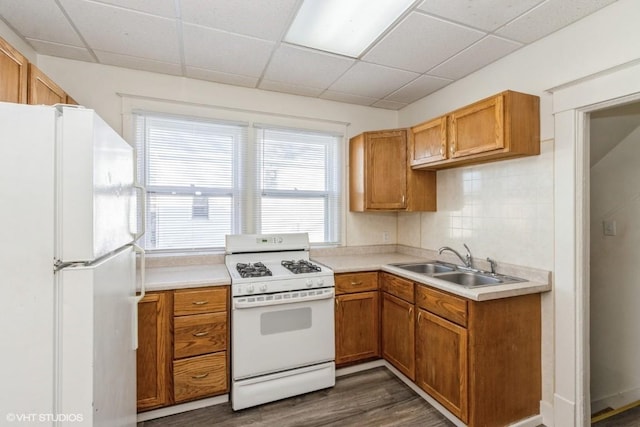 kitchen with a drop ceiling, dark hardwood / wood-style flooring, sink, and white appliances