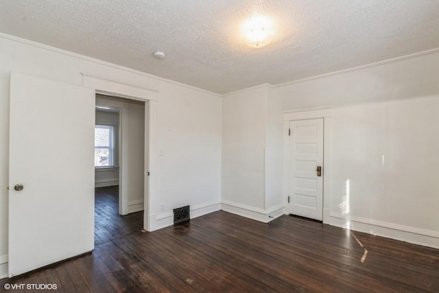 empty room featuring a textured ceiling, crown molding, and dark hardwood / wood-style floors