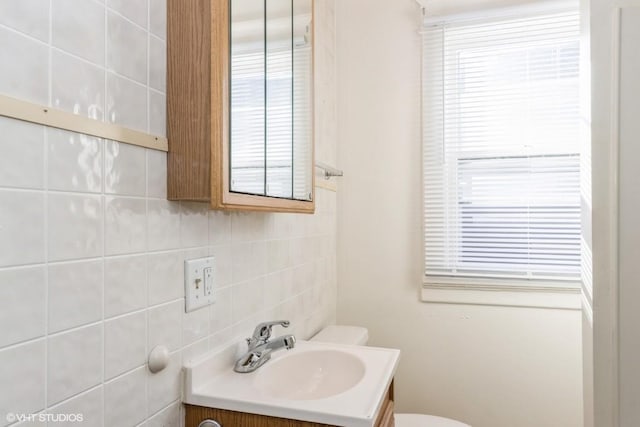 bathroom with toilet, backsplash, and vanity